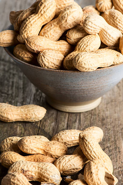 istock Peanuts in shell on wooden table in bowl 482664560