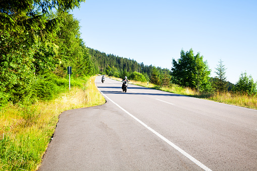 Seebach, Germany - July 10, 2015: Capture of two bikers driving on road B 500 Schwarzwaldhochstraße in Black Forest at midsummer early evening light and sunshine.