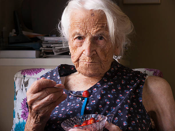 Senior lady eating strawberries stock photo