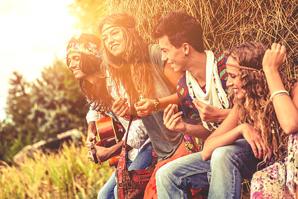 hippy grupo tocando la guitarra y bailar juntos - 1970s style women hippie retro revival fotografías e imágenes de stock