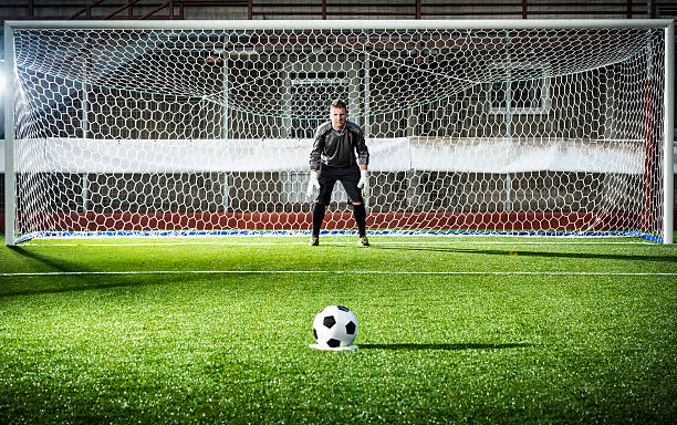 fußballspiel im stadium: stornierungsgebühr kick - torhüter stock-fotos und bilder