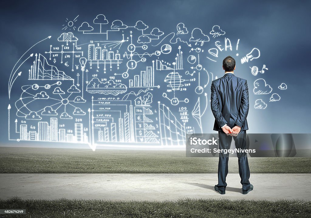 Businessman and business sketch Back view image of young businessman standing against business sketch Adult Stock Photo