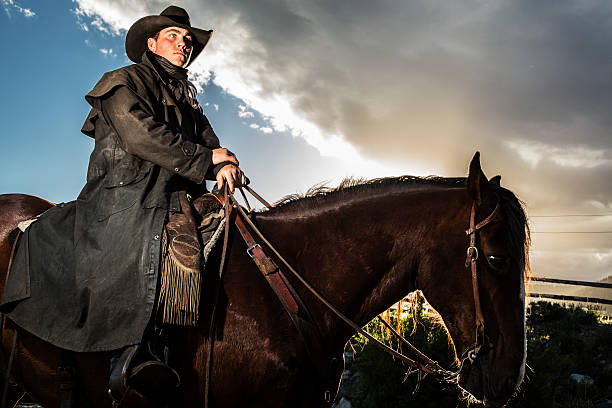 istock Real Cowboys: Man riding bay horse along ranch trail. 482674873