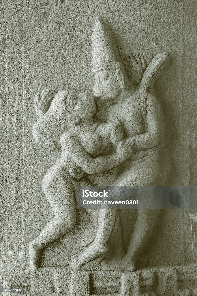 Dancing couple ancient sculpture Stone carved sculpture on a wall in Vittal temple complex in Hampi, Karnataka, India. Ancient Stock Photo