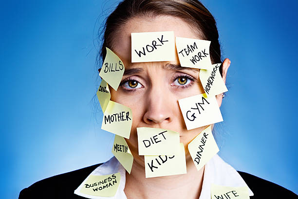istock Worried, overtired, frowning woman covered in task reminders 482678203
