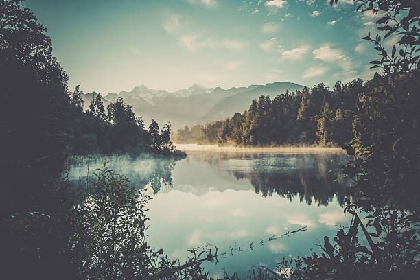 Lake Matheson Nature Panorama at Sunrise, New Zealand Lake Matheson Nature Panorama at Sunrise, New Zealand fox glacier photos stock pictures, royalty-free photos & images