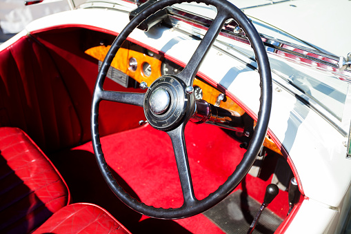 Baden-Baden, Germany - July 10, 2015: Steering wheel and cockpit of Rolls Royce oldtimer with red seats. Oldtimer seen on oldtimer meeting in Baden-Baden. Convertible car.