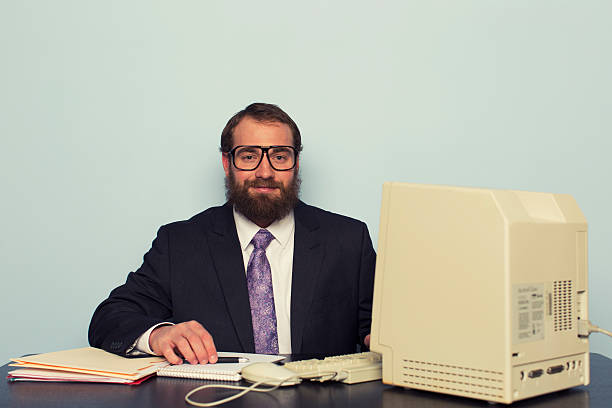 Retro Businessman A retro businessman sits at his computer ready to do some work. uncool stock pictures, royalty-free photos & images