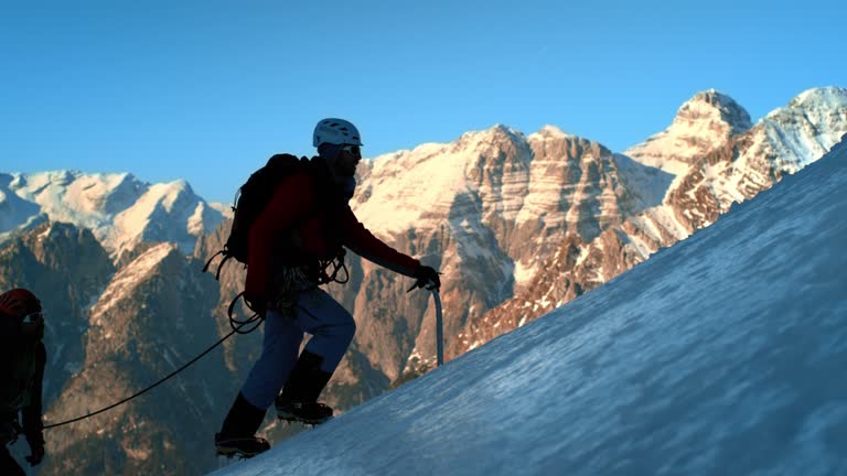 LD SLO MO mountaineers going up the steep snowy slope