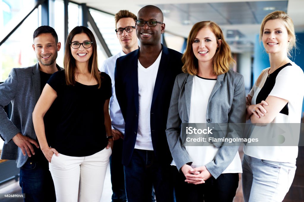 Group of young executives posing for picture Group of young executives standing, smiling at camera and posing for picture 2015 Stock Photo