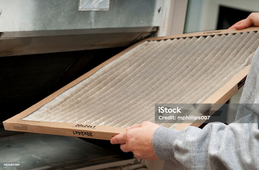 Home Air Filter Home owner changing their dirty air filter.   Filtration Stock Photo