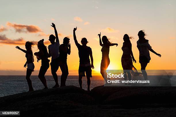 Young Party People Dancing On A Rock Stock Photo - Download Image Now - In Silhouette, Party - Social Event, Beach