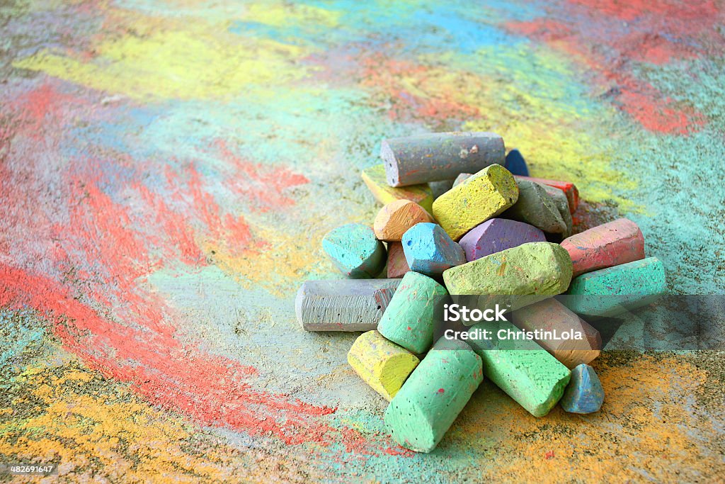 Pile of Sidewalk Chalk a collection of colorful sidewalk chalk is piled up on a rainbow drawing, outside on the pavement. Chalk - Art Equipment Stock Photo