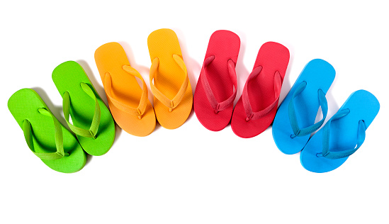 Row of colorful flip flops isolated against a white background.  Alternative version shown below: