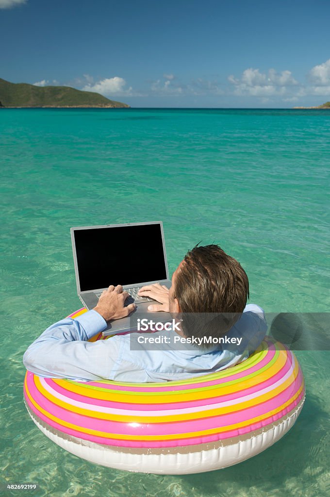 Tranquilo empresario escribiendo en computadora portátil flotante en Tropical a la bahía - Foto de stock de Humor libre de derechos