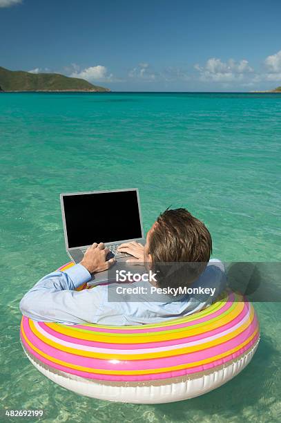 Tranquilo Empresario Escribiendo En Computadora Portátil Flotante En Tropical A La Bahía Foto de stock y más banco de imágenes de Humor