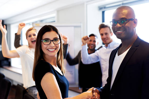 istock White colleague and black colleague shaking hands 482695016