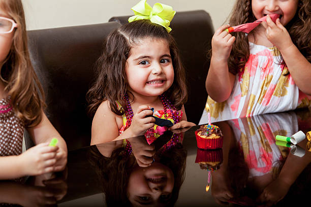 It's my birthday! Gorgeous little girl celebrating her birthday with her friends and a cupcake happy birthday cousin stock pictures, royalty-free photos & images