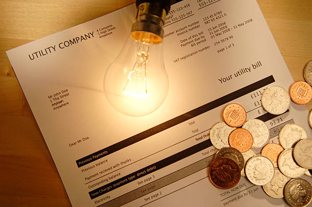 utility bill series utility bill with lightbulb and coins tungsten image stock pictures, royalty-free photos & images