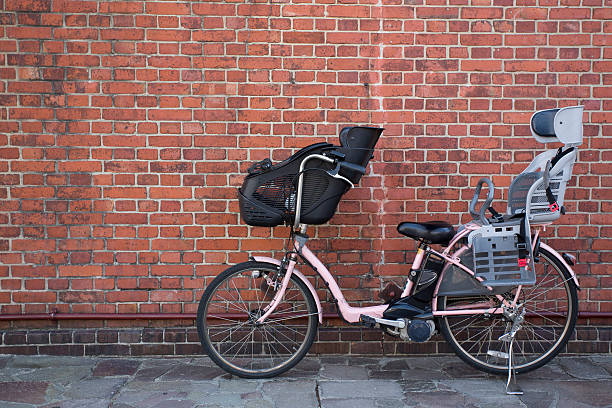 チャイルドシート付き自転車は、レンガの背景 - stationary bycicle ストックフォトと画像