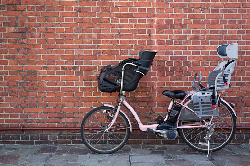 Bicycle child seat is attached with brick background