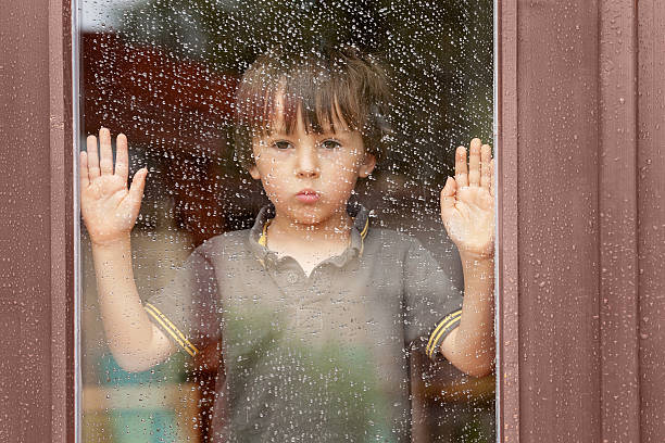 istock Little boy behind the window in the rain 482699572