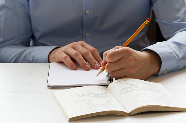 istock Student writing in a notebook and preparing for the exams 482701410