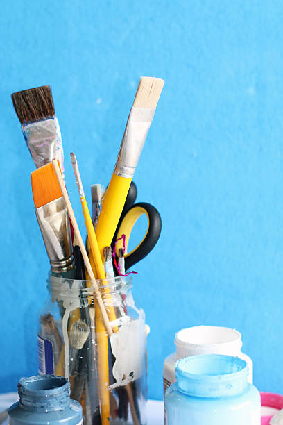 istock Paintbrushes in glass jar and open container of colors 482706224