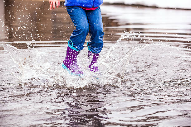 istock Young Girl Jumping in Puddle 482708437