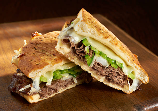 Philadelphia Cheese Steak Panini Philadelphia Cheesesteak Flatbread or Panini sandwich made with steak, provolone cheese and saute onions and bell peppers. flatbread photos stock pictures, royalty-free photos & images