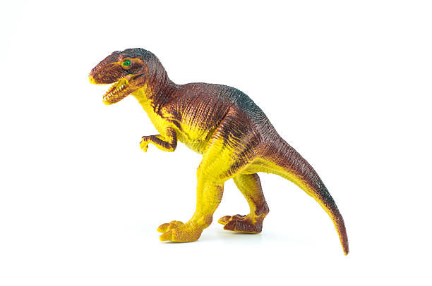 Toy dinosaur with birthday party hat on a yellow background.