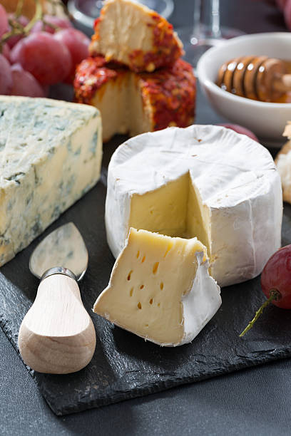 istock molded cheeses and snacks on the blackboard, vertical 482710240