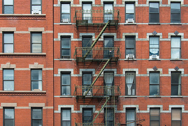 istock Old brownstone apartment building with an iron fire escape stairs 482714868