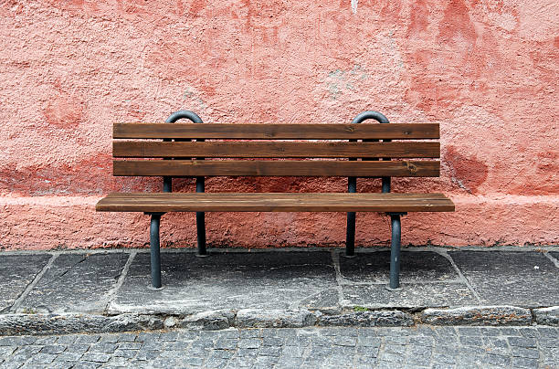 istock lonely bench in front of a pastle wall 482715786
