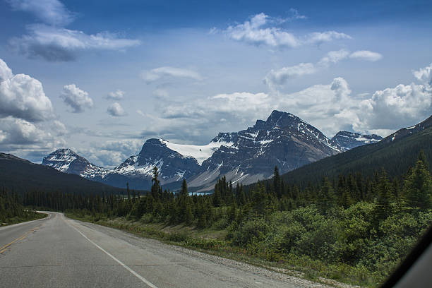 istock Mountain road with forest and snowy peaks 482717938
