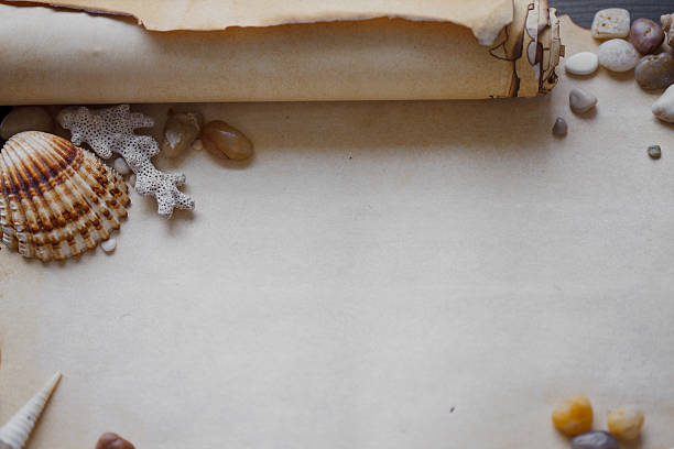 istock Old scroll of parchment with sea pebbles and seashells, nautical 482718196