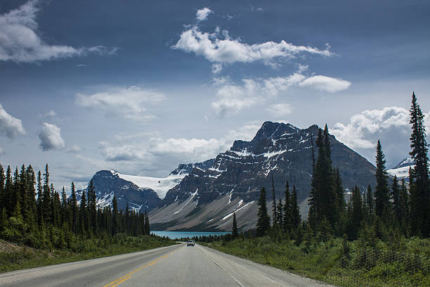 istock Mountain road with forest and snowy peaks 482719476