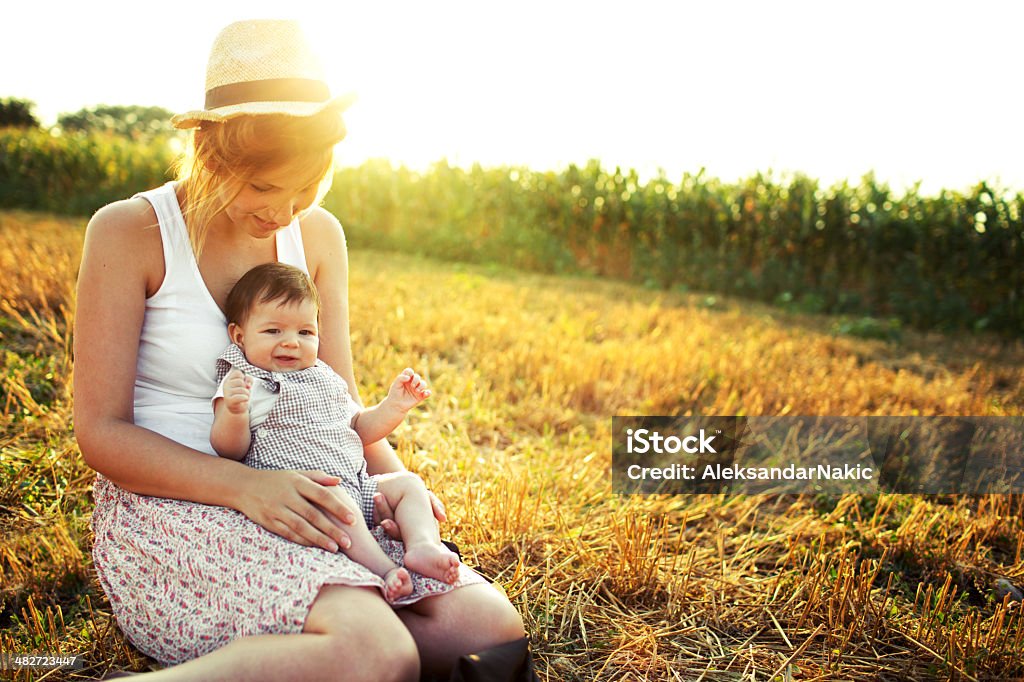 Mother and a baby Mother and a baby sitting in a grass on a beautiful day Baby - Human Age Stock Photo