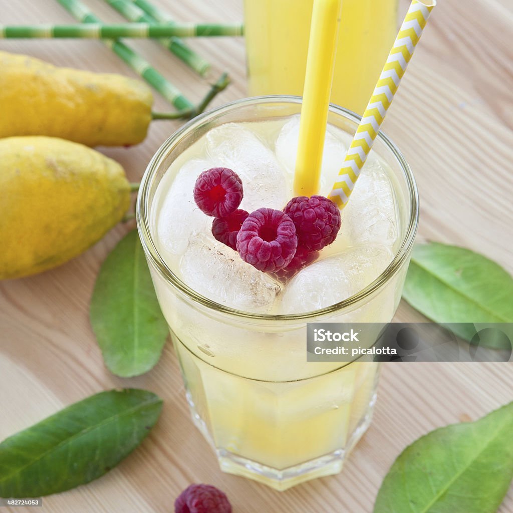 Cold lemonade with fresh lemons Cold lemonade with fresh lemons and raspberries Alcohol - Drink Stock Photo