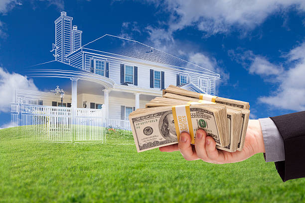 istock Handing Over Thousands of Dollars with Ghosted House Drawing Beh 482724134
