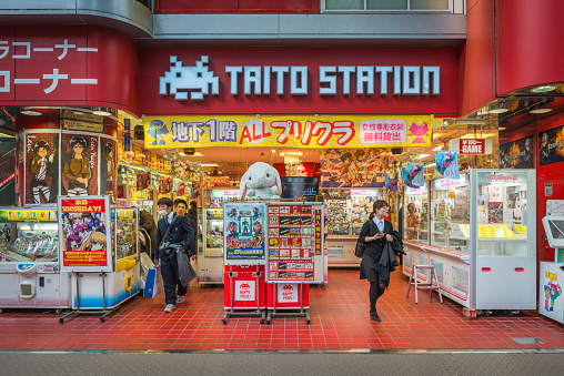 Tokyo, Japan - 30th January 2014: Youths at the entrance to a noisy and colourful gaming arcade in the Akihabara 'Electric Town' district of downtown Tokyo, Japan's vibrant capital city.