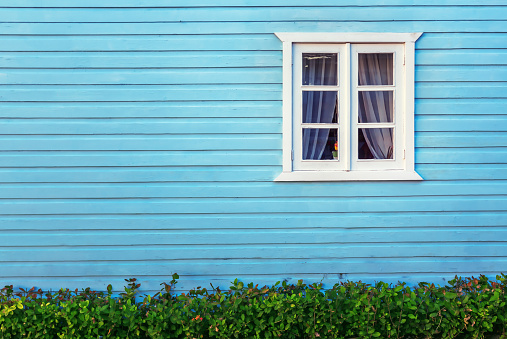 Decorative white window on an a blue  wooden wall in Punta Cana