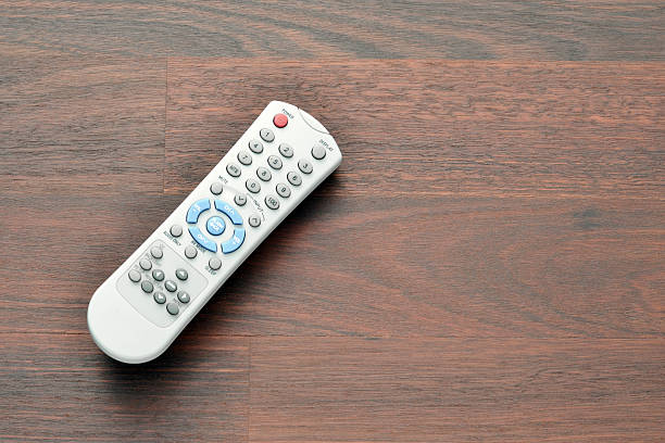 Remote Control Close up of a generic TV remote control on a wood table with copy space.   remote control on table stock pictures, royalty-free photos & images