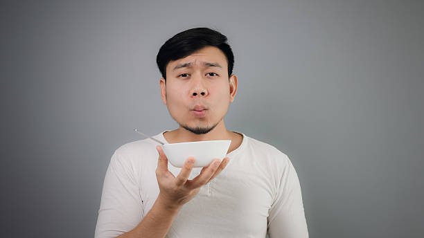 istock Asian man holding white bowl. 482728626