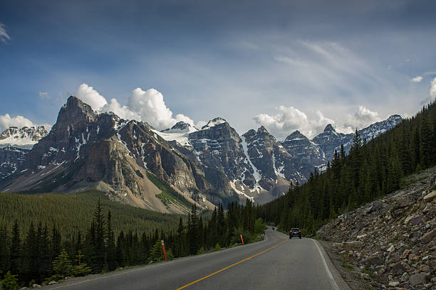 istock Mountain road with forest and snowy peaks 482730124