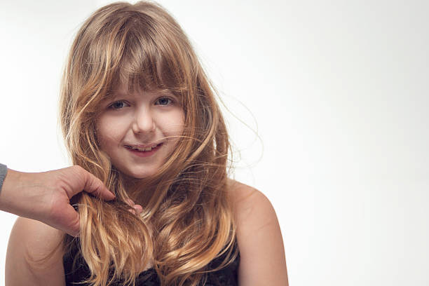 Cute little blonde girl posing in studio