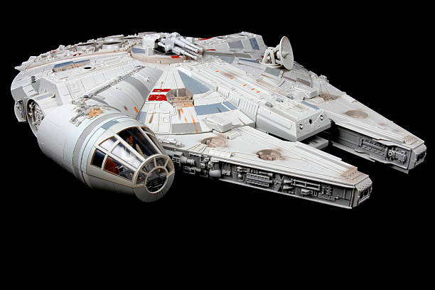 Flight Through the Black Vancouver, Сanada - February 17, 2014: A toy Millenium Falcon, from the Star Wars movie franchise, on a black background. The toy is made by Hasbro star wars stock pictures, royalty-free photos & images