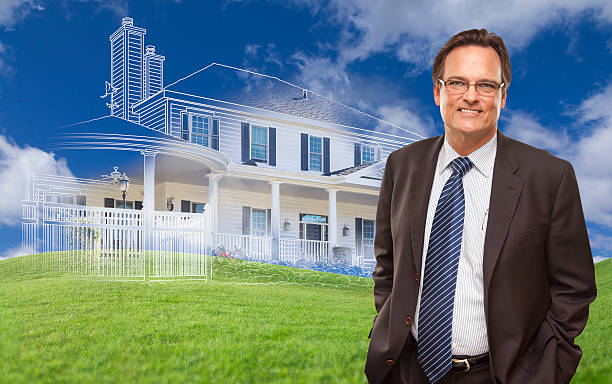 istock Smiling Businessman with Ghosted House Drawing Behind 482731210
