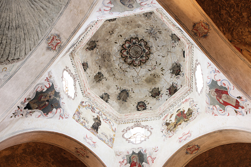 Ornately painted baroque murals and frescoes in the arched dome ceiling of San Xavier del Bac mission. Tucson, Arizona, 2014.