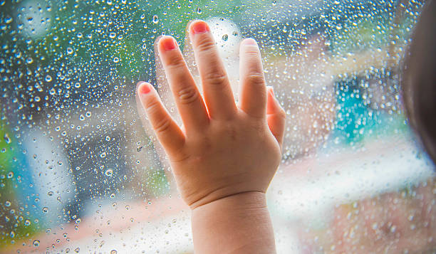 istock Rain drops on the car window and children hand . 482731458